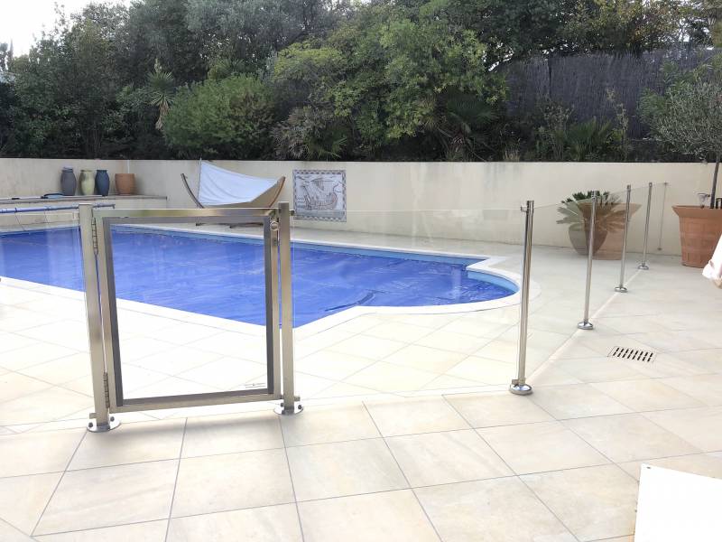 Barrière de piscine en inox et verre.